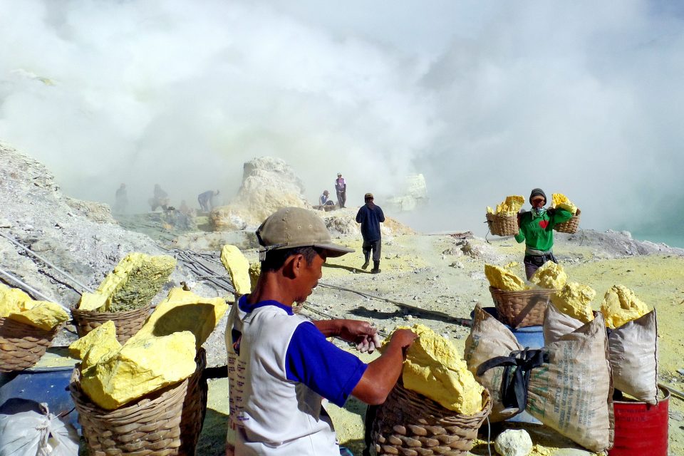 Men carrying baskets of rock