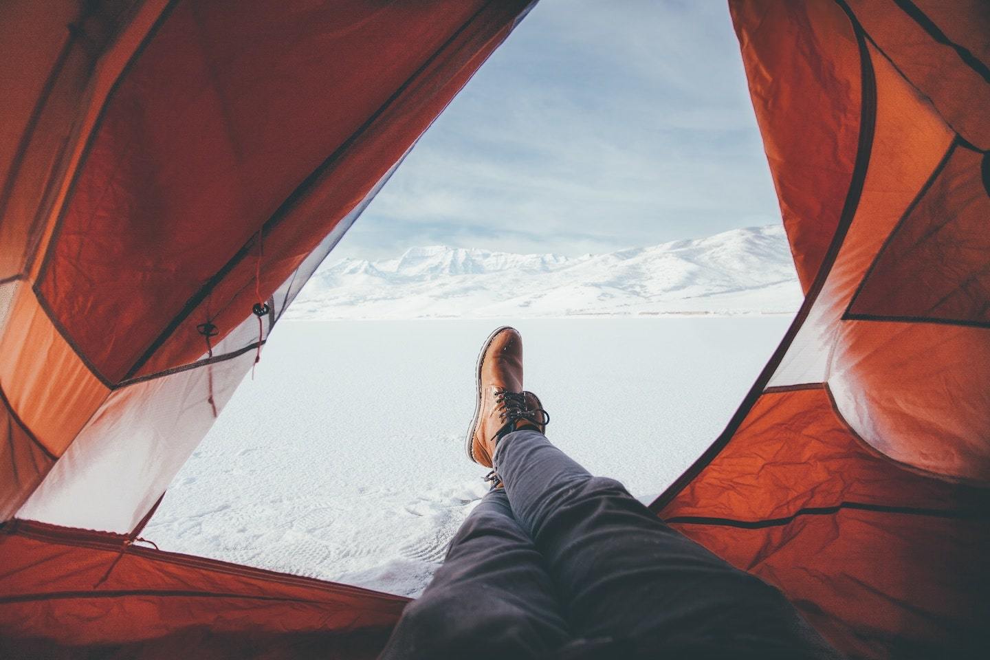 man in tent with snow outside