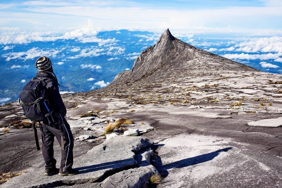 A man standing at the top of mount kinabalu