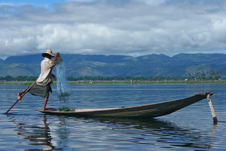 A man fishing off a canoe