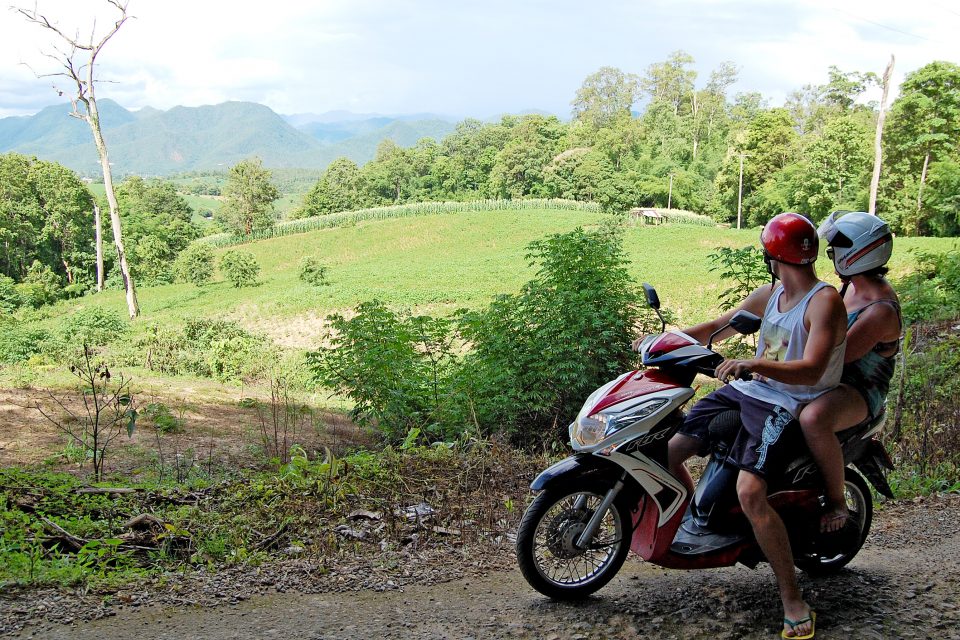 A man and woman on a parked motorbike
