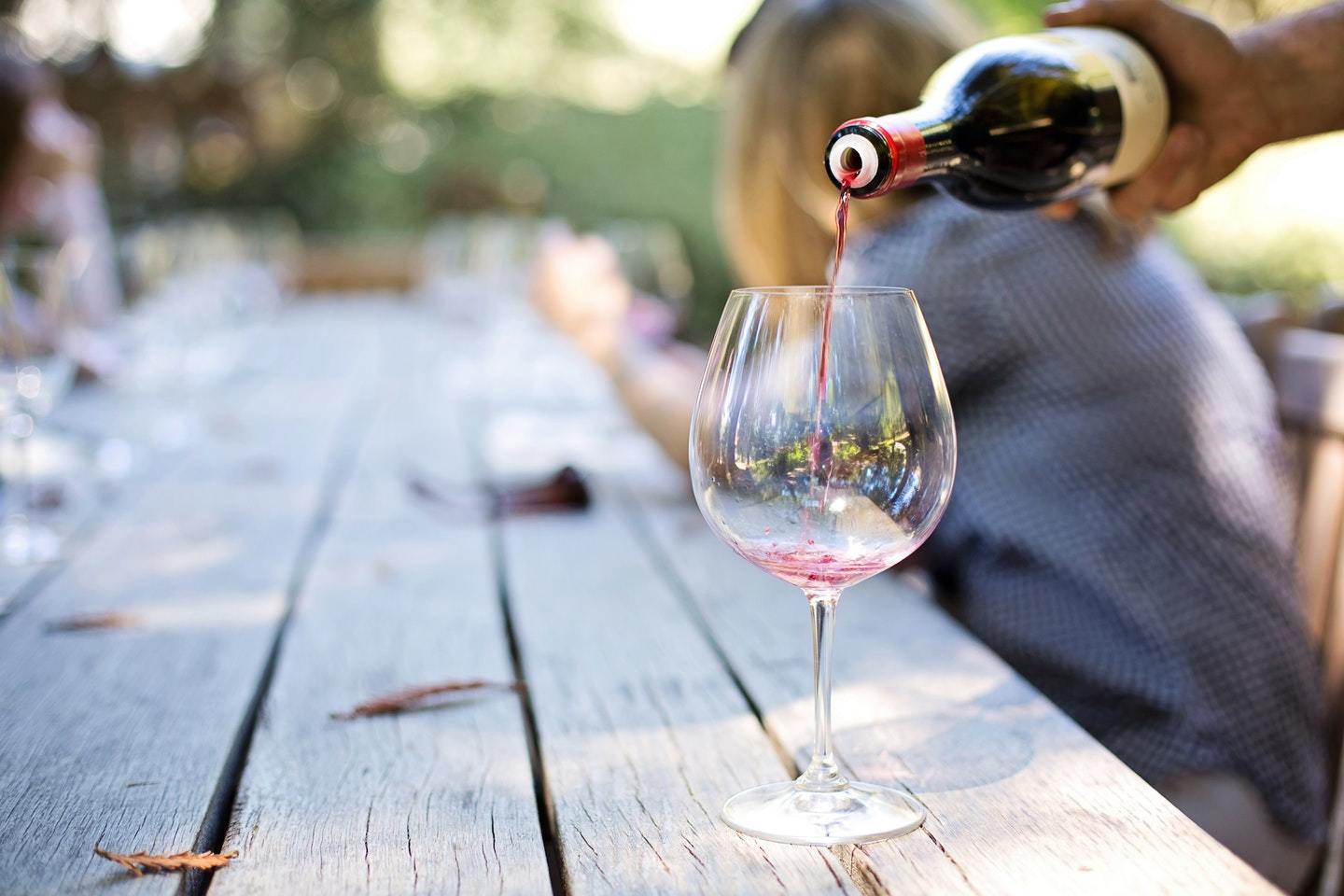 a glass of red wine being poured